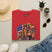 Red Mardi Gras T-shirt with mardi gras queen and American flag graphic on front.