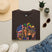 Dark brown T-shirt with Mardi Gras queen and American flag graphic on front